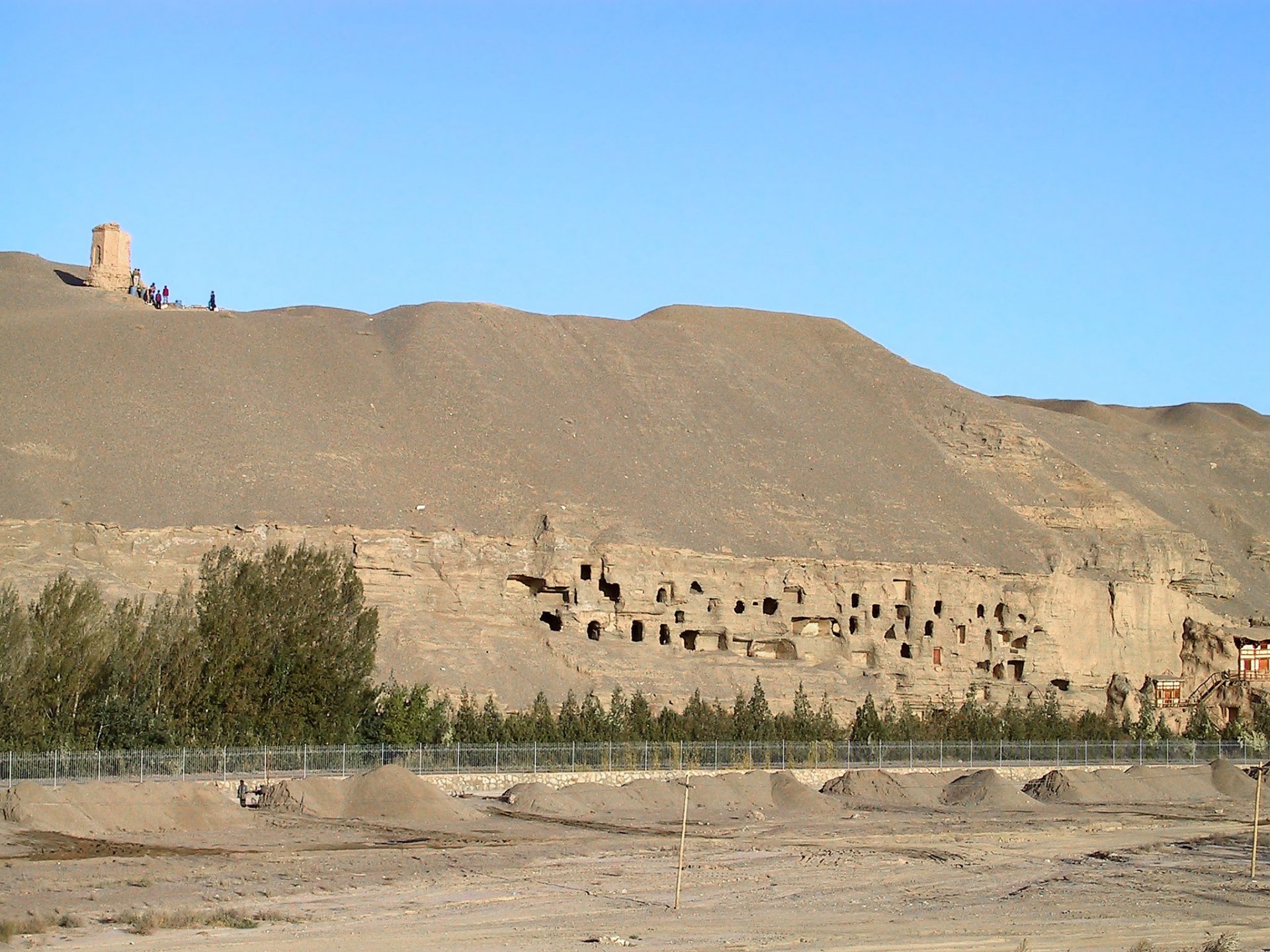 敦煌莫高窟の石窟群全景、文化交流と歴史のつながりを示す旅と交易の風景