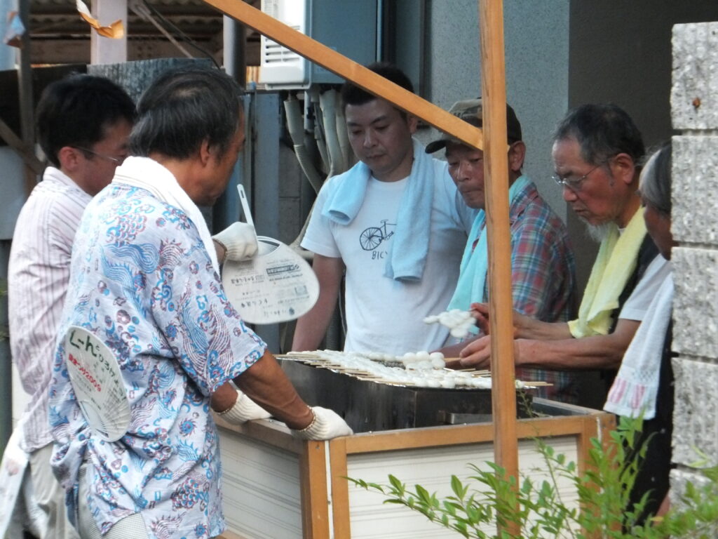 みたらし団子を汗をふきふき焼く、町内の大人たち